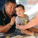 Michigan head coach Brady Hoke signs the t-shirt of Liam Woolson, 1, of Farmington Hills, during youth day at Michigan Stadium on Sunday, August 11, 2013. Melanie Maxwell | AnnArbor.com